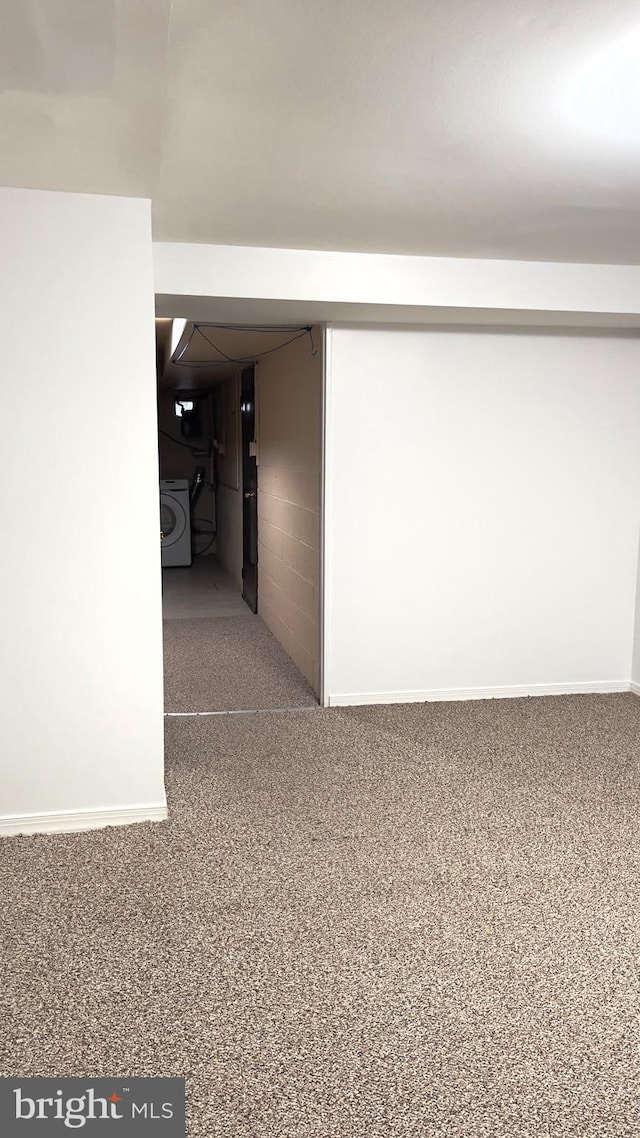 corridor with washer / dryer and carpet flooring