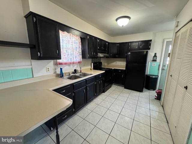 kitchen with a sink, black appliances, and dark cabinets