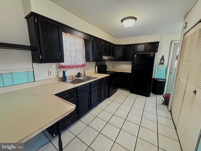 kitchen featuring dark cabinetry, a sink, and black appliances