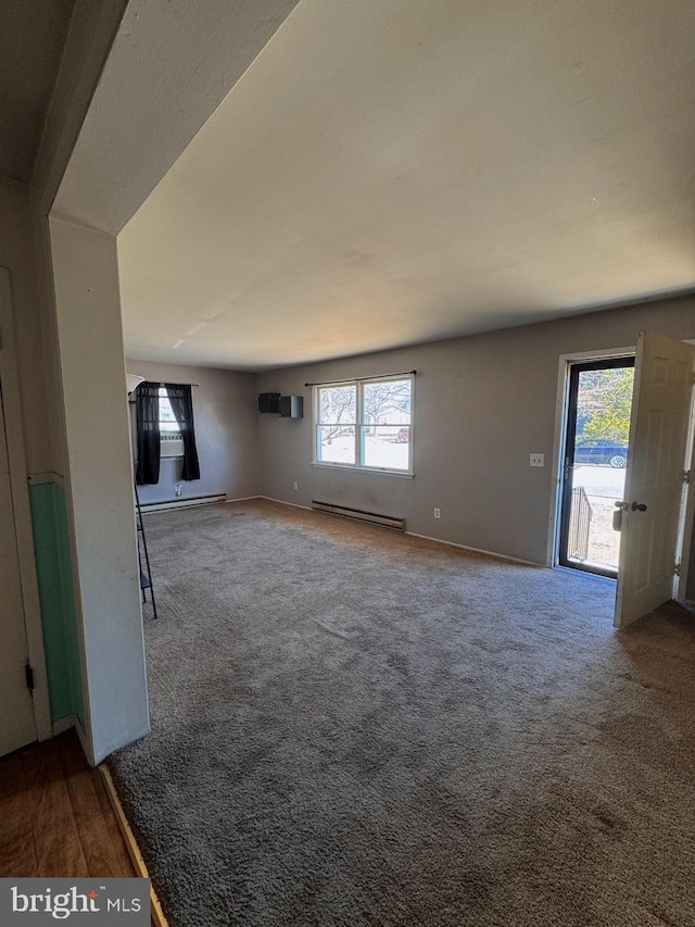 unfurnished living room with carpet floors, a baseboard radiator, and baseboards