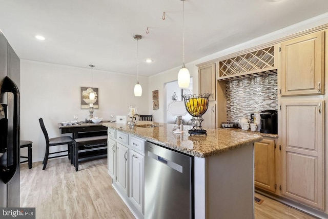 kitchen featuring light wood-style flooring, light stone counters, decorative light fixtures, a kitchen island with sink, and stainless steel dishwasher