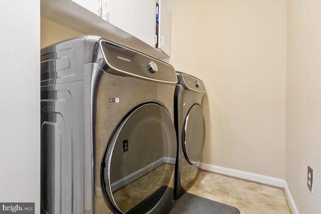 clothes washing area with cabinet space, baseboards, and separate washer and dryer