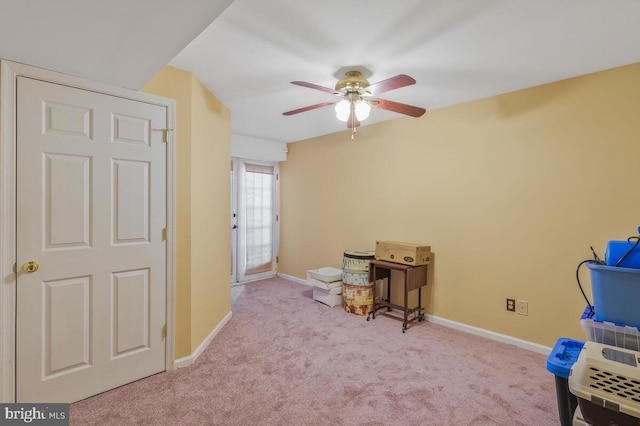 recreation room with carpet floors, a ceiling fan, and baseboards