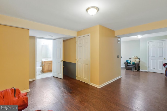 interior space with dark wood-style floors, a sink, visible vents, and baseboards