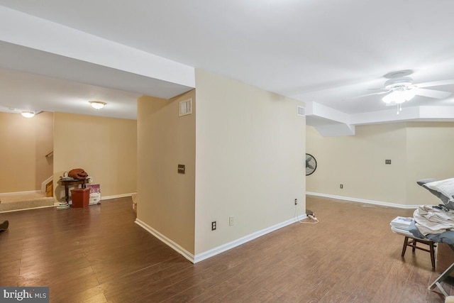 below grade area featuring stairs, wood finished floors, visible vents, and baseboards