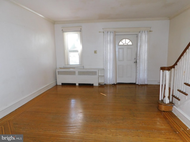 entrance foyer featuring stairs, ornamental molding, wood finished floors, and radiator