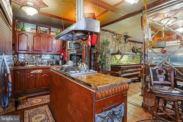 kitchen featuring a center island, crown molding, appliances with stainless steel finishes, a sink, and dark brown cabinets