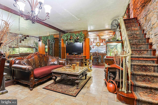 living area with an inviting chandelier, stone tile floors, stairs, and a textured ceiling