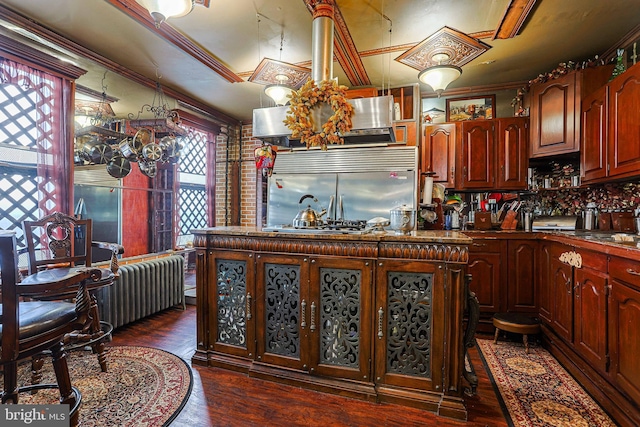kitchen with dark countertops, high end refrigerator, ornamental molding, and dark wood-style flooring