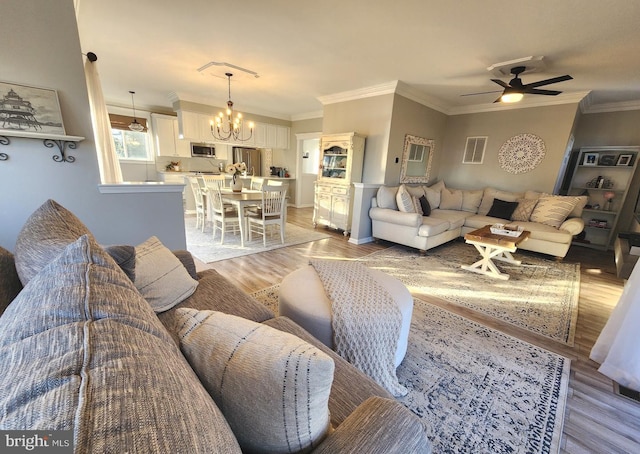 living room featuring crown molding, light wood finished floors, and ceiling fan with notable chandelier