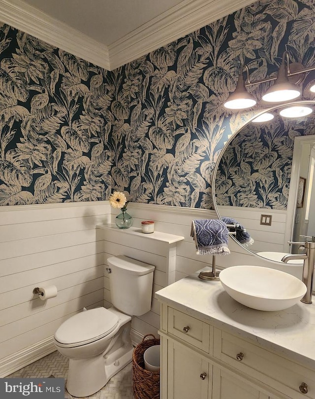 bathroom with wainscoting, crown molding, and wallpapered walls