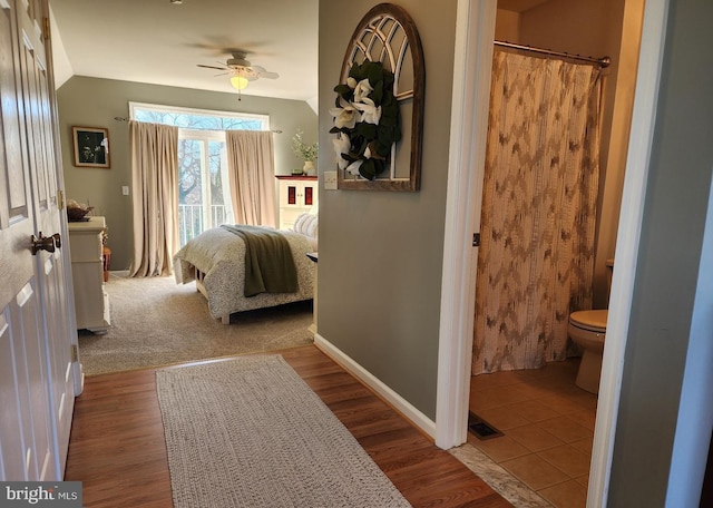 bedroom with lofted ceiling, connected bathroom, wood finished floors, access to outside, and baseboards