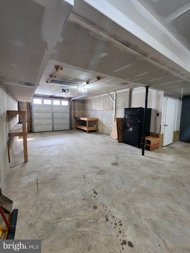 garage with visible vents, a garage door opener, and freestanding refrigerator