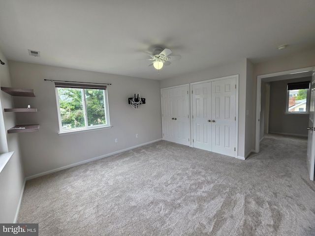 5128 Shore Dr, Huntingtown, MD 20639 - unfurnished bedroom featuring two closets, multiple windows, and carpet