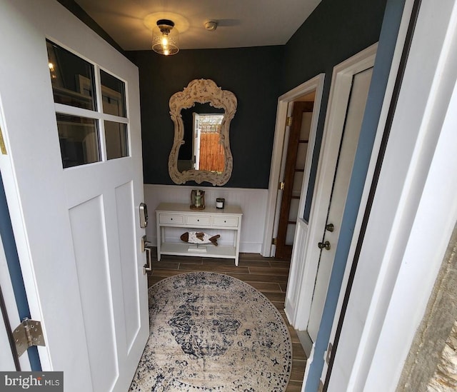 hall with wood finish floors and wainscoting