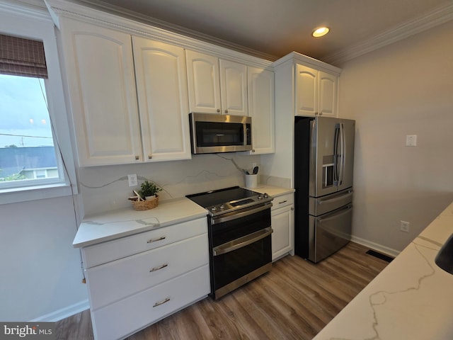 5128 Shore Dr, Huntingtown, MD 20639 - kitchen with stainless steel appliances, ornamental molding, white cabinets, wood finished floors, and baseboards