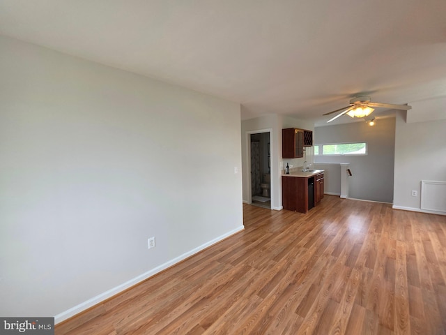 5128 Shore Dr, Huntingtown, MD 20639 - unfurnished living room with light wood finished floors, baseboards, a sink, and a ceiling fan