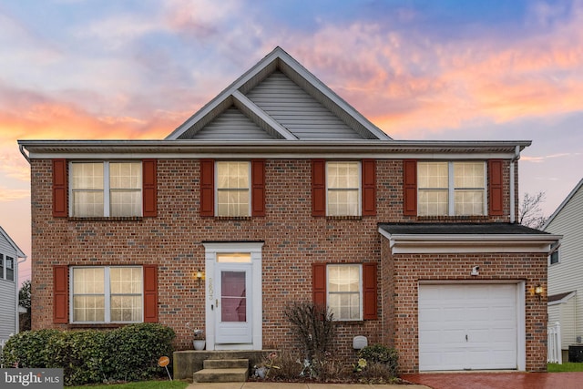 view of front of property featuring an attached garage, driveway, and brick siding