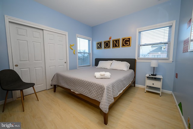 bedroom featuring a closet, light wood-style flooring, and baseboards