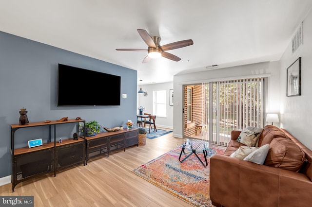 living room with a ceiling fan, wood finished floors, visible vents, and baseboards