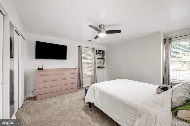 bedroom with visible vents, multiple windows, light carpet, and a ceiling fan