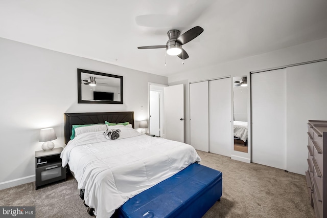 bedroom with ceiling fan, two closets, and light carpet