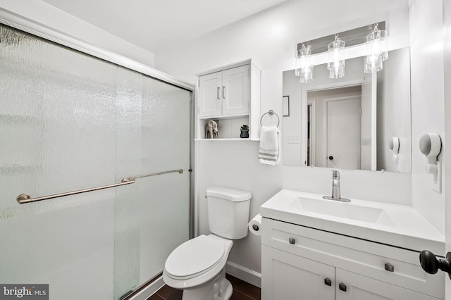 bathroom with vanity, a shower stall, and toilet