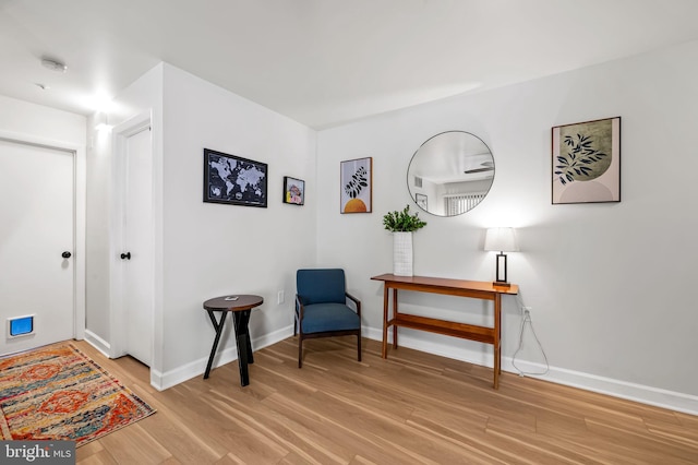 sitting room featuring light wood-style flooring and baseboards