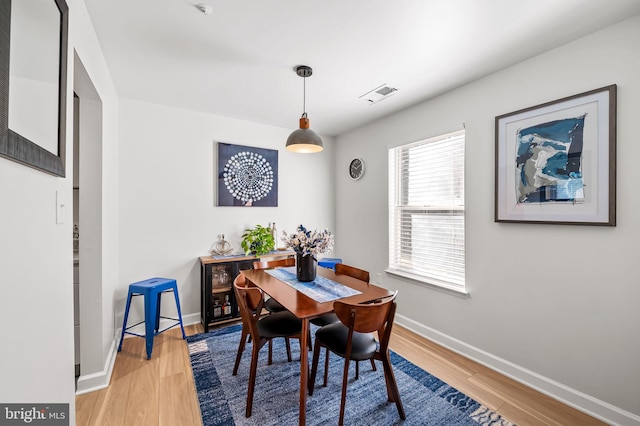 dining room featuring visible vents, baseboards, and light wood-style floors