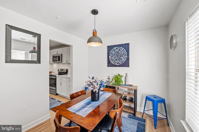 dining room with light wood finished floors and baseboards