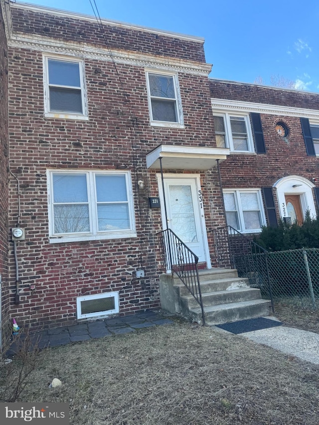 townhome / multi-family property featuring brick siding and fence