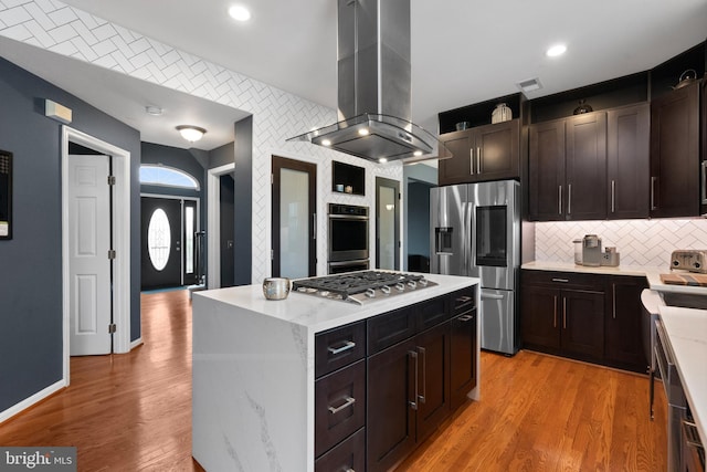 kitchen featuring visible vents, recessed lighting, appliances with stainless steel finishes, island exhaust hood, and decorative backsplash
