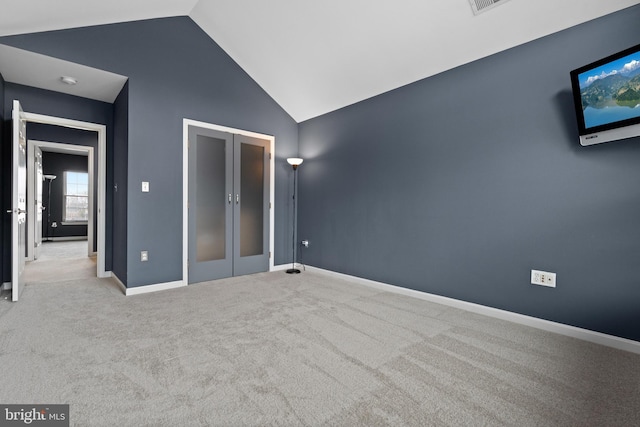 unfurnished bedroom with a closet, carpet flooring, baseboards, and lofted ceiling