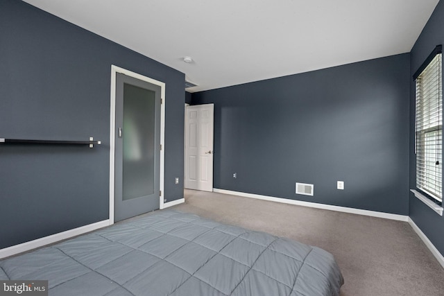 unfurnished bedroom with carpet flooring, visible vents, and baseboards