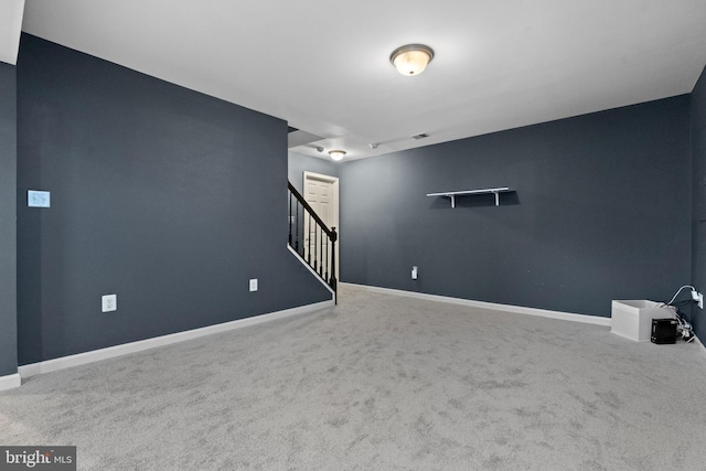 below grade area featuring carpet floors, baseboards, and stairs