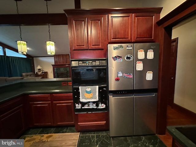 kitchen with reddish brown cabinets, beam ceiling, dark countertops, dobule oven black, and freestanding refrigerator