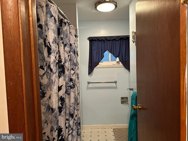 full bathroom featuring a shower with curtain, baseboards, and tile patterned floors