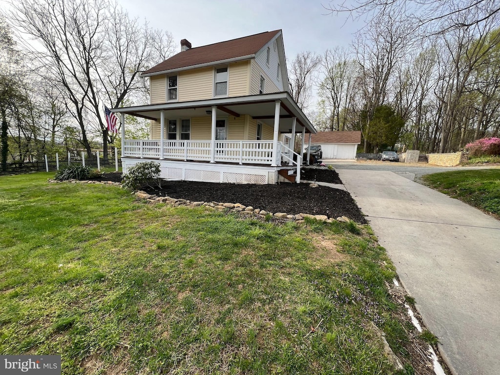 country-style home with a chimney, a front lawn, and a porch