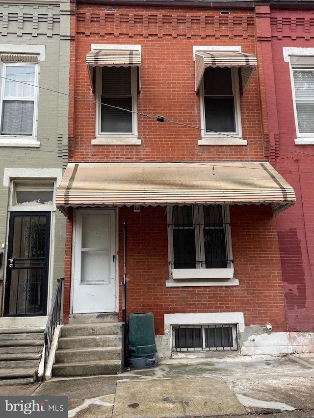 view of exterior entry with brick siding