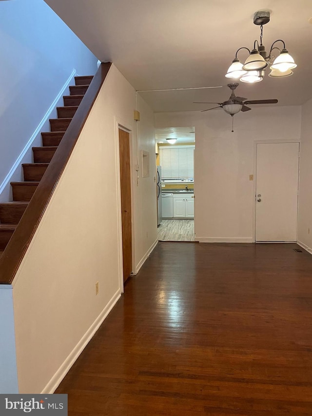 interior space featuring dark wood-style floors, baseboards, stairway, and a chandelier