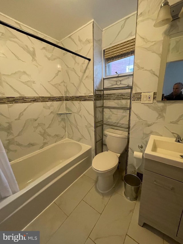 bathroom featuring marble finish floor, tile walls, shower / bath combination with curtain, toilet, and vanity