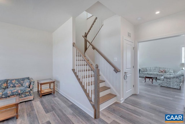 stairway featuring recessed lighting, wood finished floors, visible vents, and baseboards