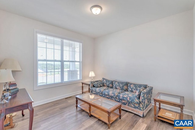 living room with visible vents, baseboards, and wood finished floors