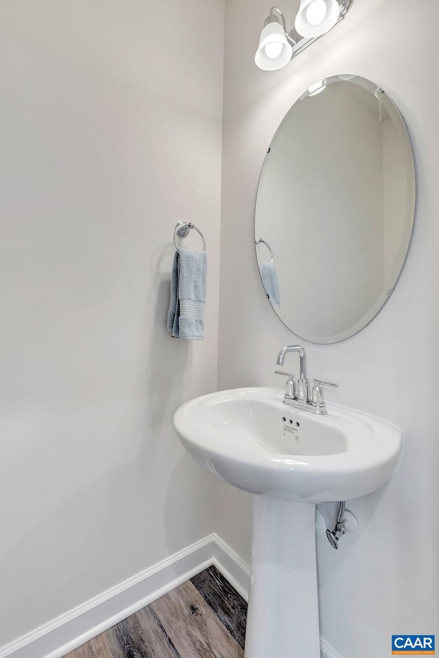 bathroom featuring a sink, baseboards, and wood finished floors