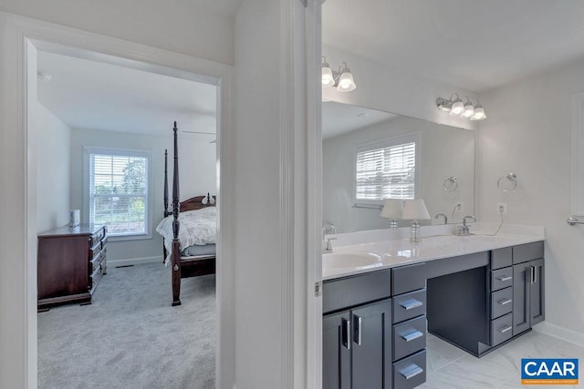 bathroom with baseboards, a sink, ensuite bath, and double vanity