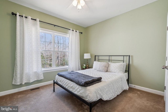 carpeted bedroom featuring a ceiling fan, visible vents, and baseboards