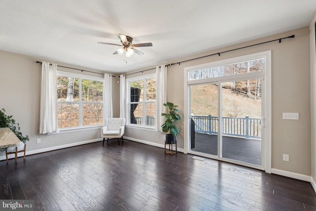 unfurnished room featuring a healthy amount of sunlight, dark wood-style floors, and baseboards