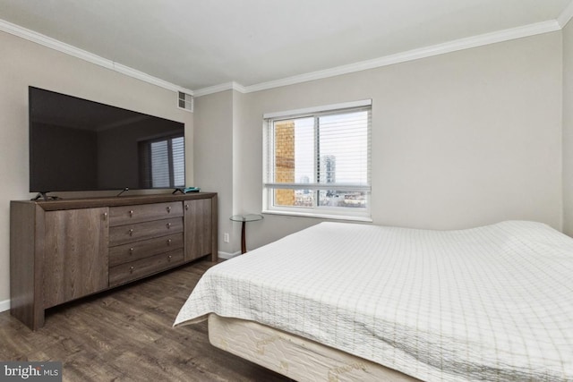 bedroom featuring ornamental molding, dark wood-type flooring, visible vents, and baseboards