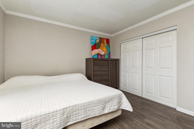 bedroom with ornamental molding, a closet, dark wood finished floors, and baseboards