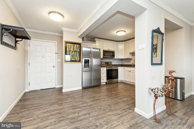 kitchen featuring dark wood-style floors, white cabinetry, appliances with stainless steel finishes, and ornamental molding